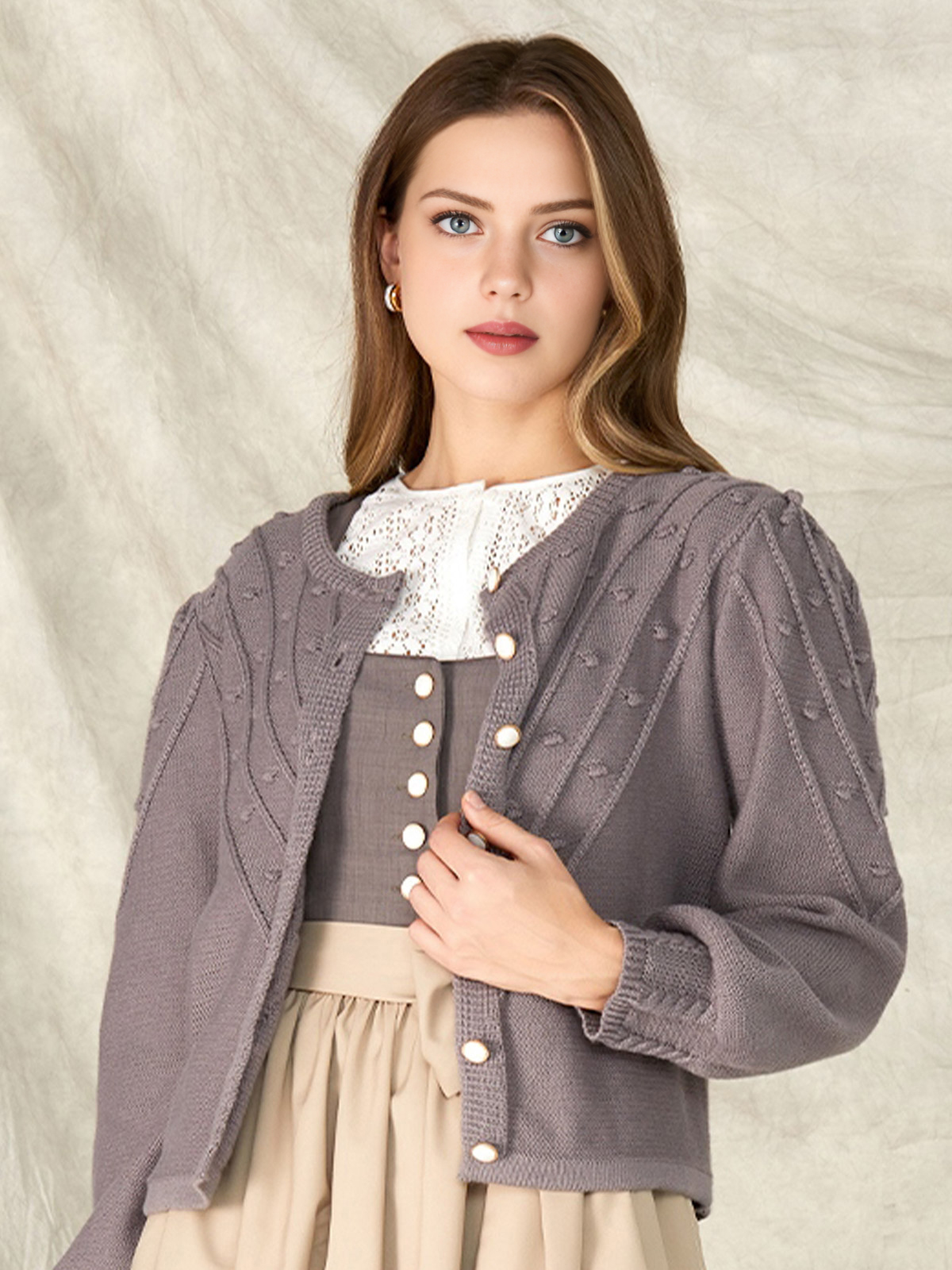 Ein grau meliertes Strickdirndl mit weißer Schürze – eine moderne Interpretation des klassischen Dirndls